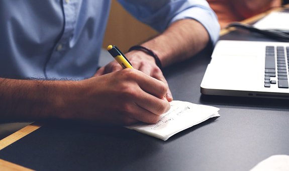 Man met pen die plan schrijft